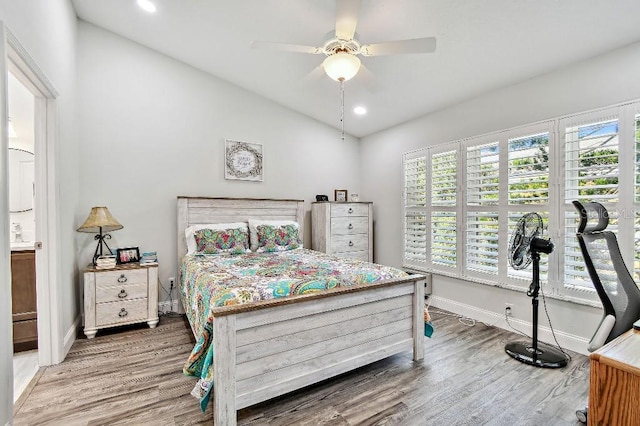 2291 Americus Blvd W Unit 41, Clearwater, FL 33763 - bedroom with baseboards, vaulted ceiling, recessed lighting, ensuite bathroom, and wood finished floors