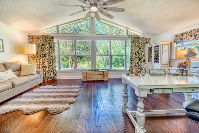 living room featuring baseboards, ceiling fan, dark wood-style floors, a textured ceiling, and vaulted ceiling