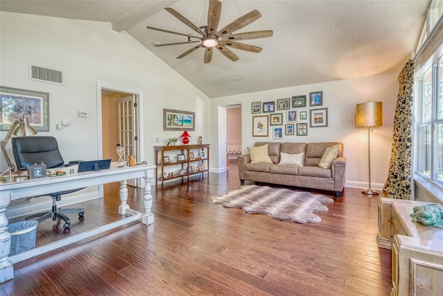 living area featuring a ceiling fan, visible vents, hardwood / wood-style flooring, beam ceiling, and high vaulted ceiling