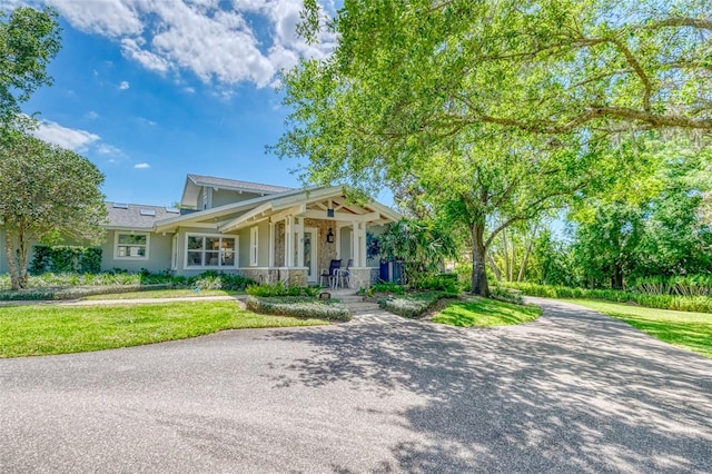 898 Cypress Lakeview Ct, Tarpon Springs, FL 34688 - view of front facade with covered porch, a front yard, and stucco siding