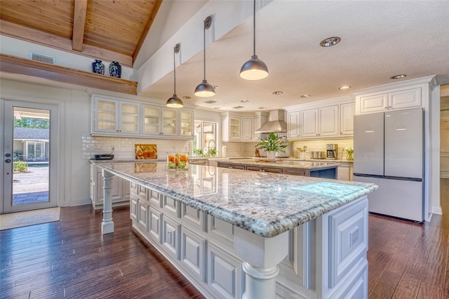 898 Cypress Lakeview Ct, Tarpon Springs, FL 34688 - kitchen featuring freestanding refrigerator, a large island, wall chimney range hood, white cabinetry, and dark wood finished floors