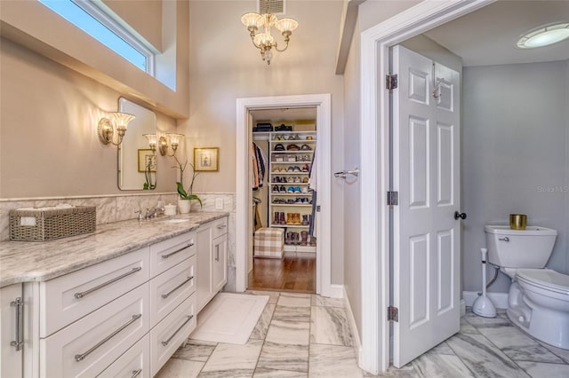 898 Cypress Lakeview Ct, Tarpon Springs, FL 34688 - full bath featuring marble finish floors, toilet, vanity, a chandelier, and a spacious closet