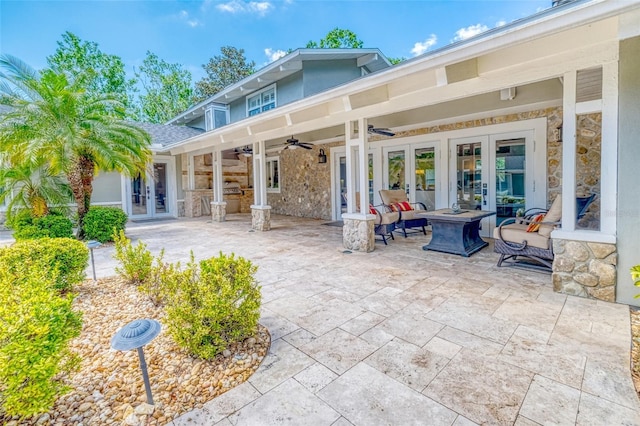 898 Cypress Lakeview Ct, Tarpon Springs, FL 34688 - back of property featuring french doors, stone siding, a patio, a ceiling fan, and an outdoor fire pit