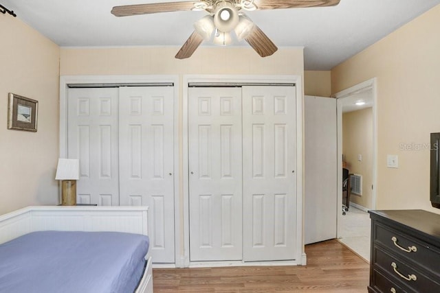 3214 W Rogers Ave, Tampa, FL 33611 - bedroom featuring two closets, light wood-style floors, and ceiling fan