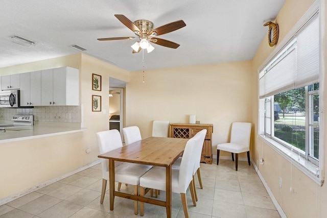 3214 W Rogers Ave, Tampa, FL 33611 - dining space featuring ceiling fan, light tile patterned floors, and baseboards