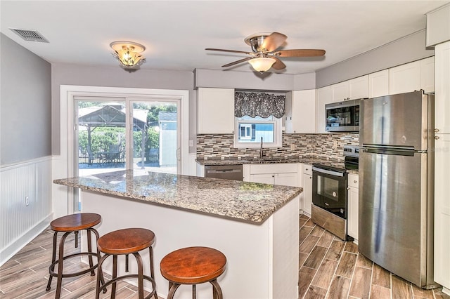 3045 Stratford Dr, Largo, FL 33771 - kitchen with wood tiled floor, visible vents, appliances with stainless steel finishes, and a sink