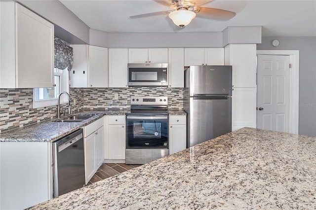 3045 Stratford Dr, Largo, FL 33771 - kitchen with a sink, wood finished floors, ceiling fan, light stone counters, and appliances with stainless steel finishes
