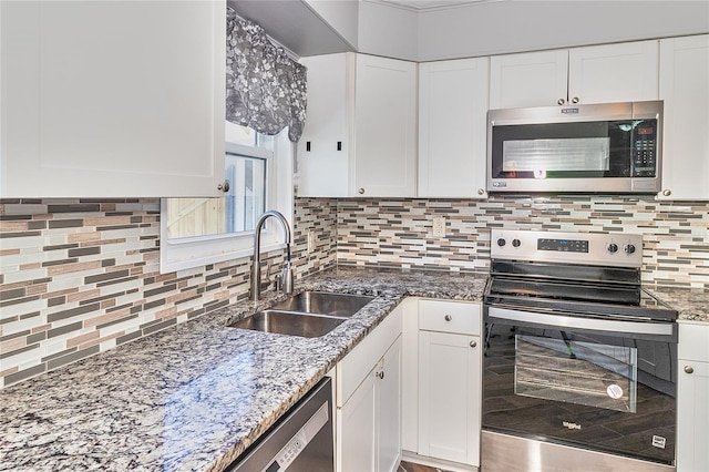 3045 Stratford Dr, Largo, FL 33771 - kitchen with white cabinets, appliances with stainless steel finishes, decorative backsplash, and a sink