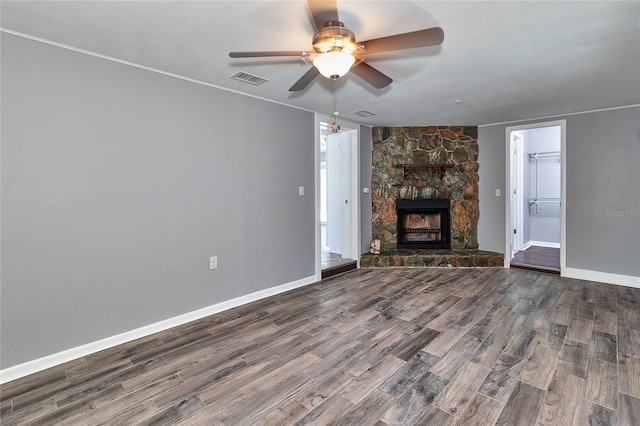 3045 Stratford Dr, Largo, FL 33771 - unfurnished living room featuring a stone fireplace, a ceiling fan, wood finished floors, and baseboards
