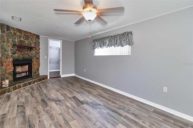 3045 Stratford Dr, Largo, FL 33771 - unfurnished living room with wood finished floors, a stone fireplace, ceiling fan, baseboards, and visible vents