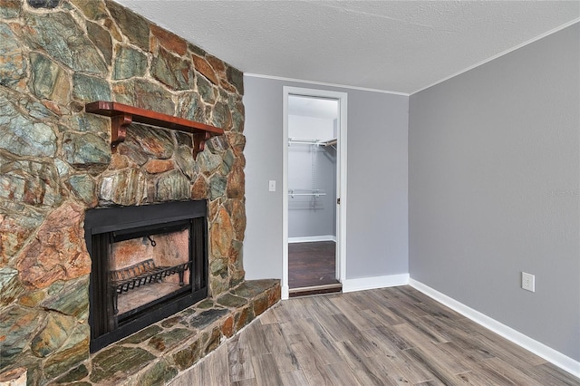 3045 Stratford Dr, Largo, FL 33771 - unfurnished living room featuring wood finished floors, crown molding, baseboards, a fireplace, and a textured ceiling