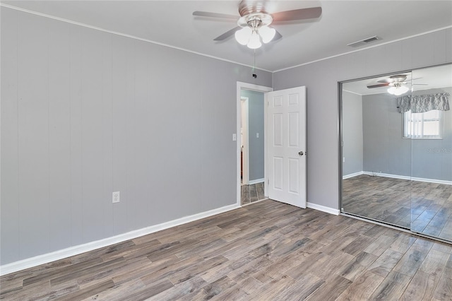 3045 Stratford Dr, Largo, FL 33771 - unfurnished bedroom with baseboards, visible vents, wood finished floors, a closet, and ceiling fan
