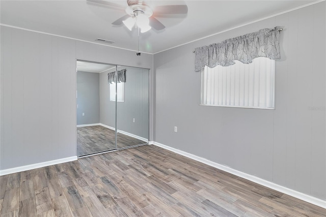 3045 Stratford Dr, Largo, FL 33771 - unfurnished bedroom featuring wood finished floors, visible vents, a closet, baseboards, and ceiling fan
