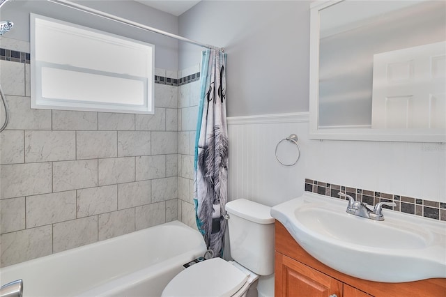 3045 Stratford Dr, Largo, FL 33771 - bathroom featuring shower / tub combo, toilet, vanity, and a wainscoted wall