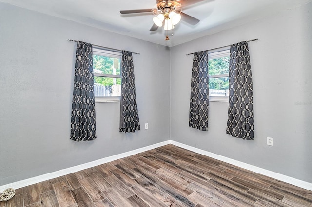 3045 Stratford Dr, Largo, FL 33771 - spare room featuring baseboards, plenty of natural light, a ceiling fan, and dark wood-style floors