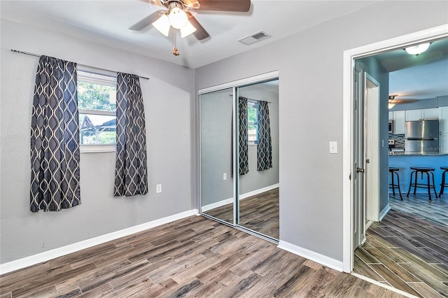3045 Stratford Dr, Largo, FL 33771 - unfurnished bedroom featuring visible vents, baseboards, freestanding refrigerator, wood finished floors, and a closet