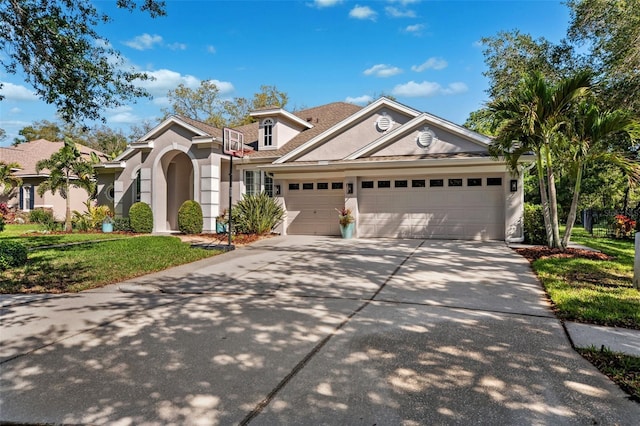 15930 Sorawater Dr, Lithia, FL 33547 - view of front of property with driveway, an attached garage, stucco siding, and a front lawn