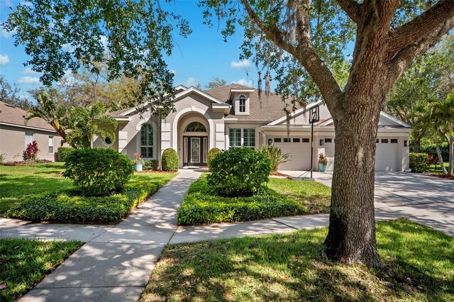 15930 Sorawater Dr, Lithia, FL 33547 - view of front of property with a garage, stucco siding, concrete driveway, and a front lawn