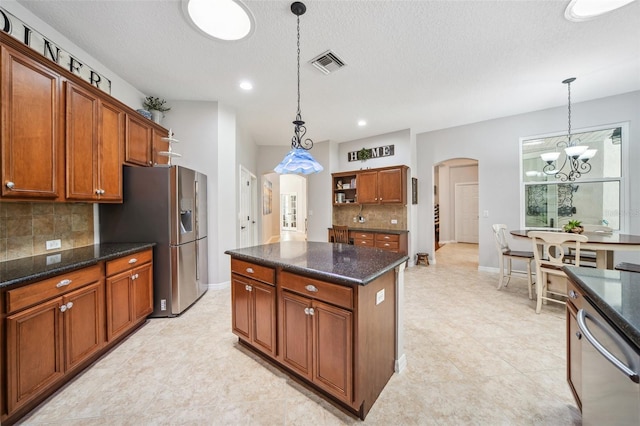 15930 Sorawater Dr, Lithia, FL 33547 - kitchen with arched walkways, tasteful backsplash, stainless steel appliances, a chandelier, and baseboards