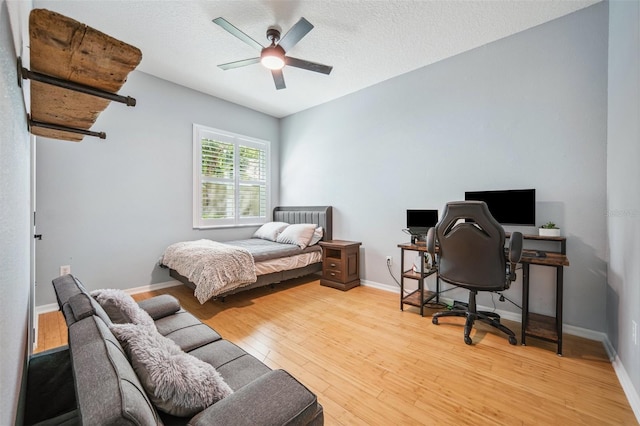 15930 Sorawater Dr, Lithia, FL 33547 - bedroom with light wood-style floors, an office area, baseboards, ceiling fan, and a textured ceiling