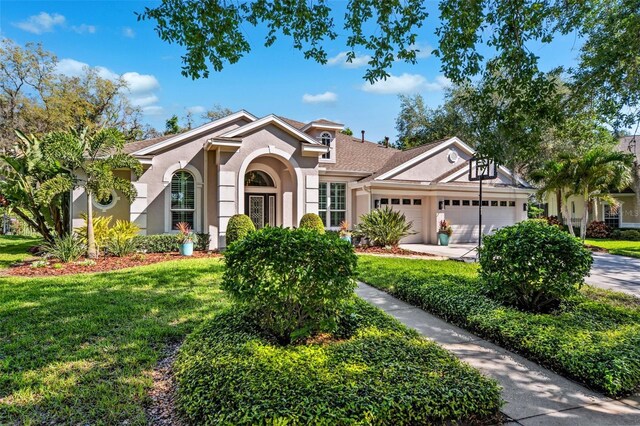 15930 Sorawater Dr, Lithia, FL 33547 - view of front of house featuring stucco siding, an attached garage, a front yard, and concrete driveway