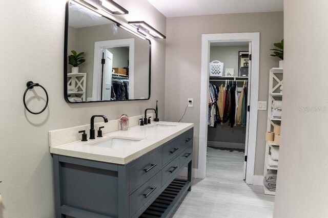 600 Eleuthera Dr, Punta Gorda, FL 33950 - full bathroom featuring a walk in closet, double vanity, a sink, and wood finished floors