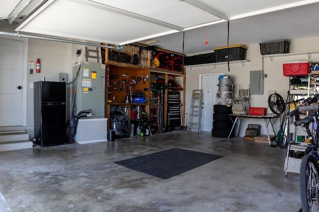600 Eleuthera Dr, Punta Gorda, FL 33950 - garage with electric panel, a workshop area, freestanding refrigerator, and heating unit