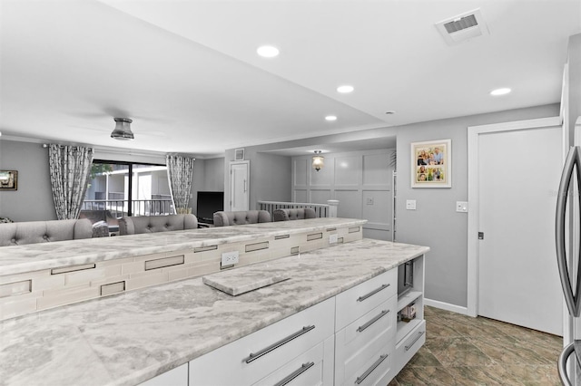 105 4th Ave NE Unit 219, Saint Petersburg, FL 33701 - kitchen featuring visible vents, baseboards, recessed lighting, white cabinetry, and light stone counters