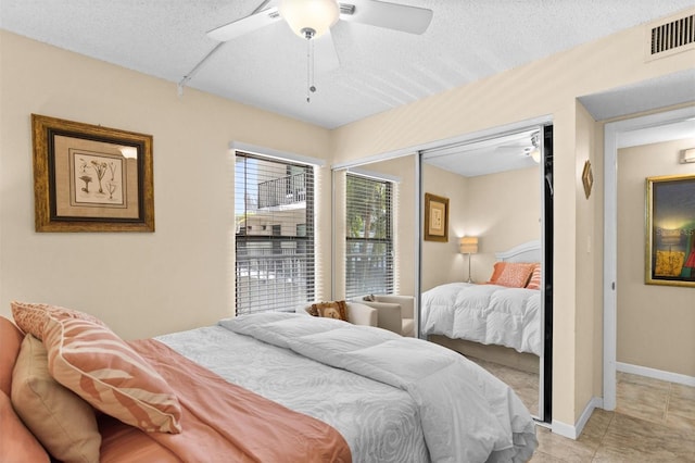 105 4th Ave NE Unit 219, Saint Petersburg, FL 33701 - bedroom with visible vents, a closet, a textured ceiling, a ceiling fan, and light tile patterned floors