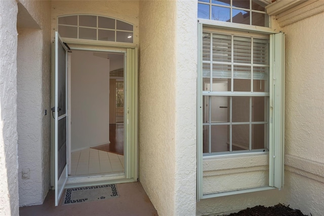entrance to property featuring stucco siding
