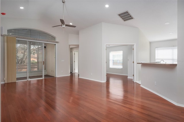 unfurnished living room featuring wood finished floors, ceiling fan, visible vents, and a wealth of natural light