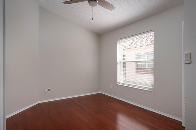 empty room with dark wood-style flooring, baseboards, and a ceiling fan