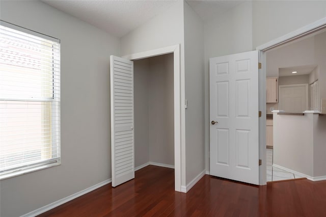 unfurnished bedroom with baseboards and wood finished floors