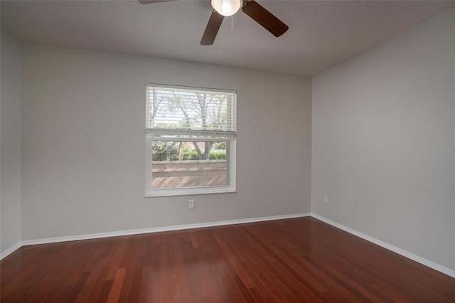 empty room with ceiling fan, baseboards, a textured ceiling, and wood finished floors