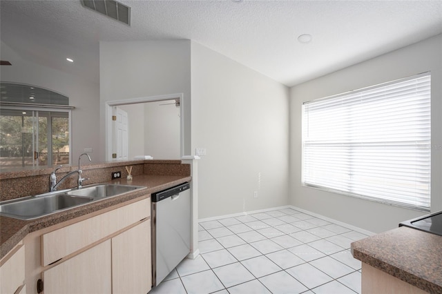 kitchen with stainless steel dishwasher, a sink, light brown cabinetry, and a healthy amount of sunlight