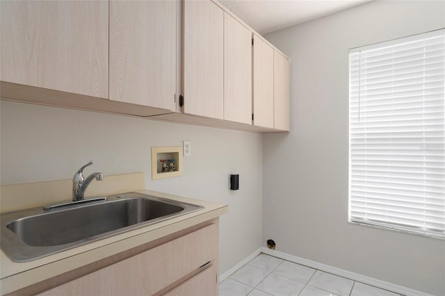 washroom featuring baseboards, a sink, cabinet space, electric dryer hookup, and hookup for a washing machine