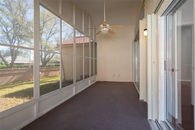 unfurnished sunroom featuring ceiling fan