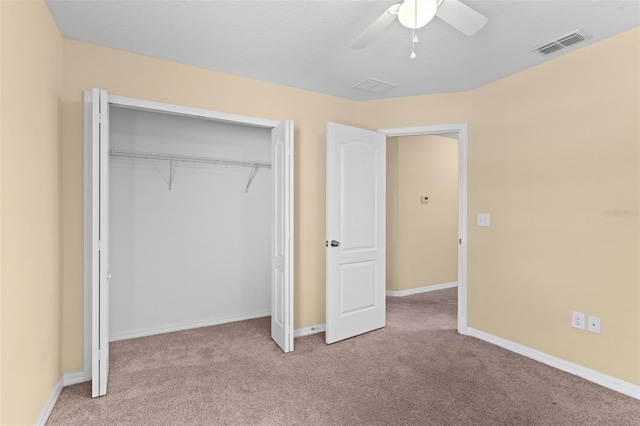 unfurnished bedroom featuring a closet, baseboards, visible vents, ceiling fan, and carpet