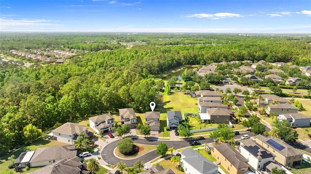 drone / aerial view featuring a residential view and a forest view
