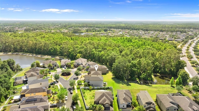 aerial view featuring a forest view, a residential view, and a water view