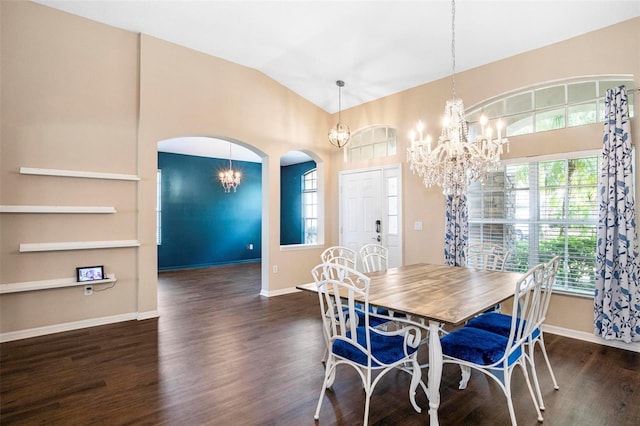 dining space featuring arched walkways, wood finished floors, lofted ceiling, a notable chandelier, and baseboards