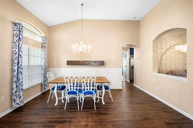 dining area with arched walkways, vaulted ceiling, and wood finished floors