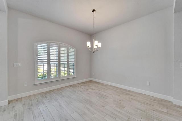 5419 Knights Landing Dr, Lakeland, FL 33810 - spare room with a notable chandelier, light wood-type flooring, and baseboards
