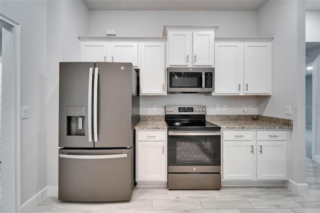5419 Knights Landing Dr, Lakeland, FL 33810 - kitchen featuring stainless steel appliances, light stone countertops, white cabinets, and baseboards