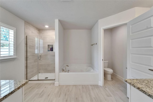 5419 Knights Landing Dr, Lakeland, FL 33810 - bathroom with toilet, a bath, a stall shower, and wood finished floors