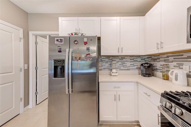 6333 Milestone Loop, Palmetto, FL 34221 - kitchen featuring white cabinets, light countertops, backsplash, light tile patterned flooring, and stainless steel fridge