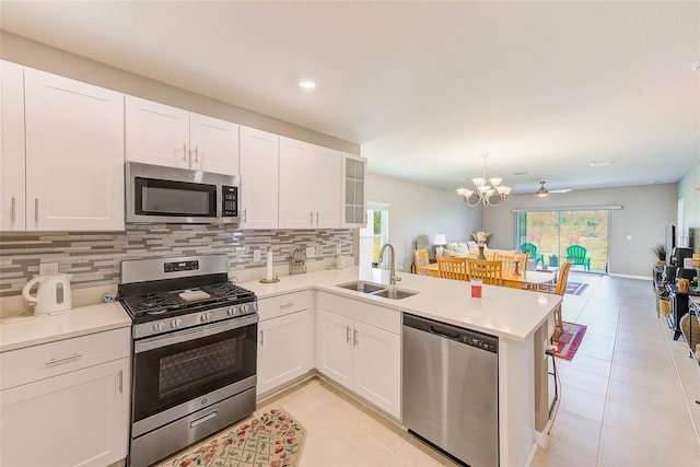 6333 Milestone Loop, Palmetto, FL 34221 - kitchen with decorative backsplash, stainless steel appliances, a sink, and light tile patterned floors