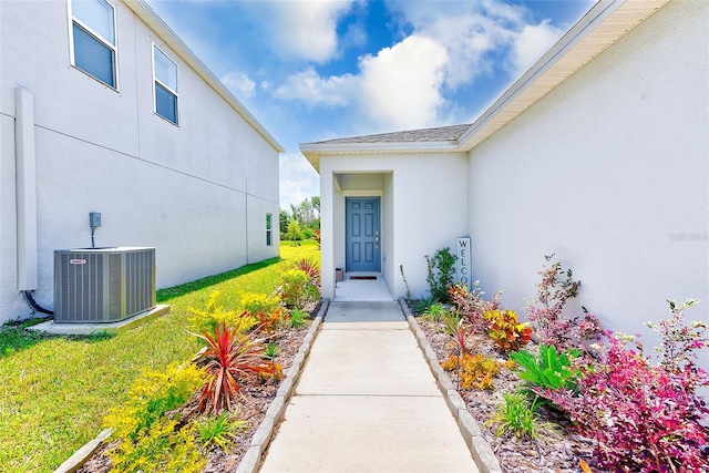 6333 Milestone Loop, Palmetto, FL 34221 - entrance to property with stucco siding, central AC unit, and a lawn