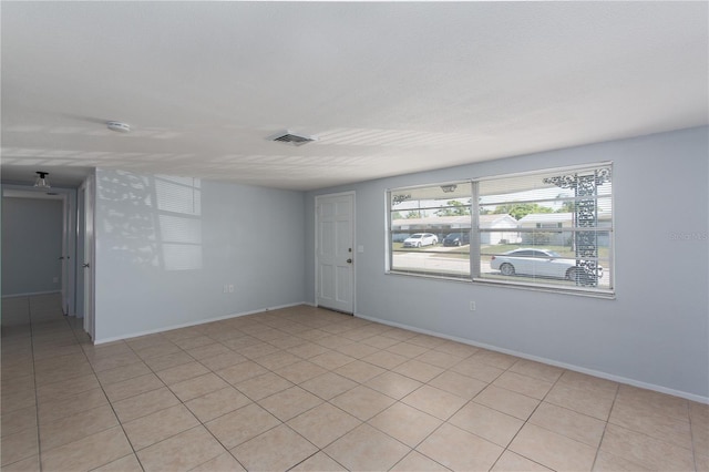 unfurnished room featuring visible vents, baseboards, and light tile patterned flooring