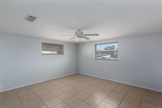 unfurnished room with light tile patterned flooring, baseboards, a ceiling fan, and visible vents